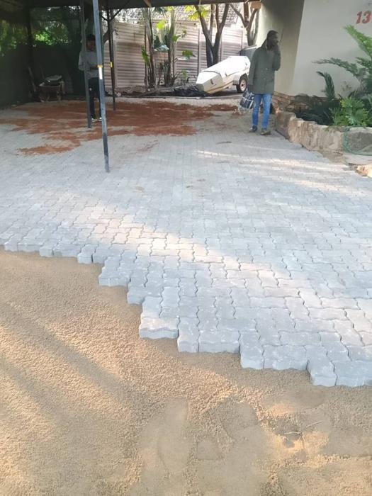 Driveway paving in progress with worker